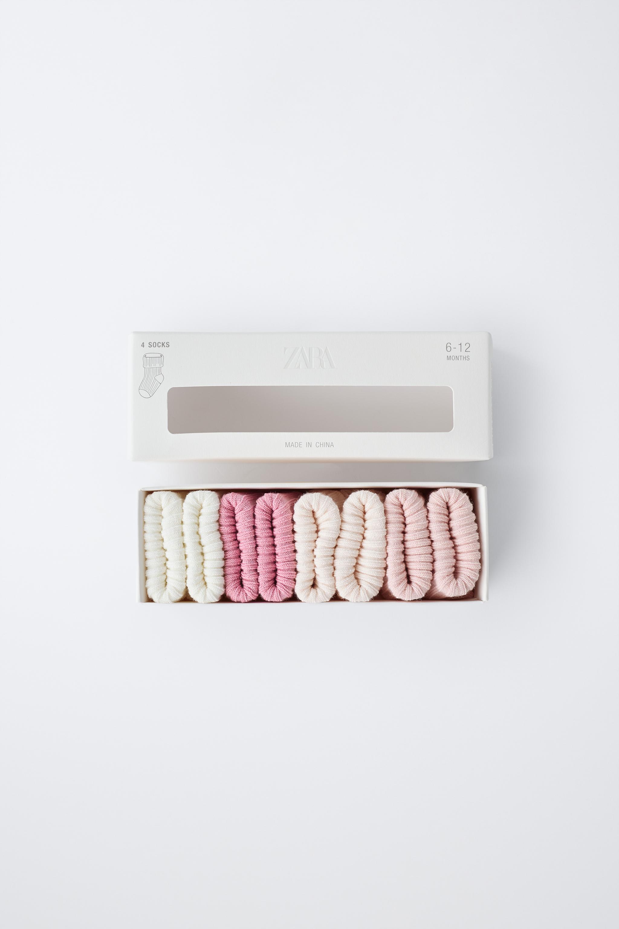 Упаковка из четырех цветных пар носков в коробке.