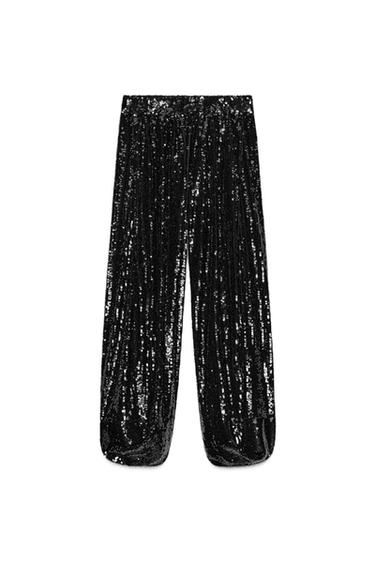 Front view of black sequinned trousers, mid-rise, elasticated waist and elasticated voluminous hems.