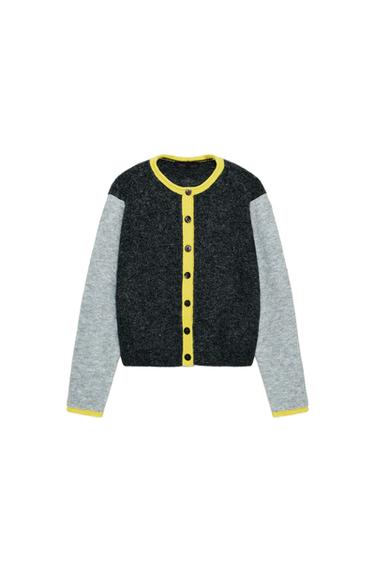 Front view of a multicoloured knitted jacket with a round neck, long grey sleeves, front button fastening and yellow trim.