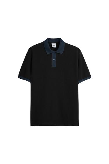 Front view of a black polo shirt with a dark blue collar and cuffs and a button fastening.