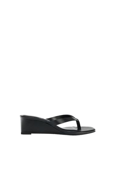 Black wedge toe-post sandal in side view against a white background.
