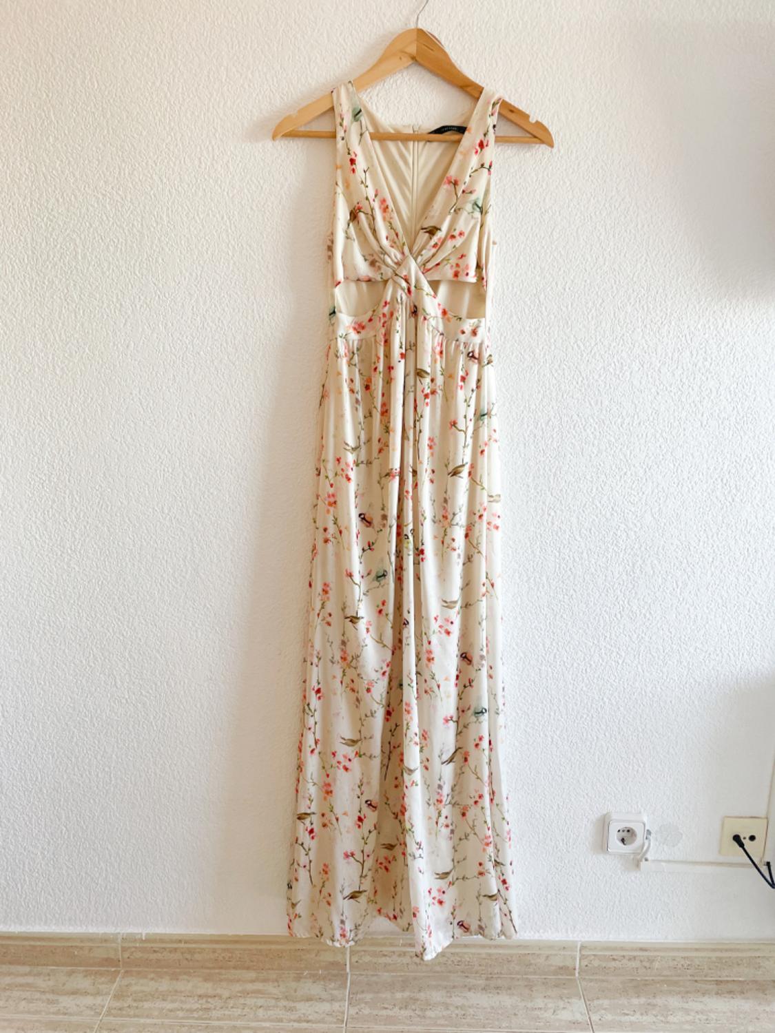 Front view of a long dress with a light floral print and straps.