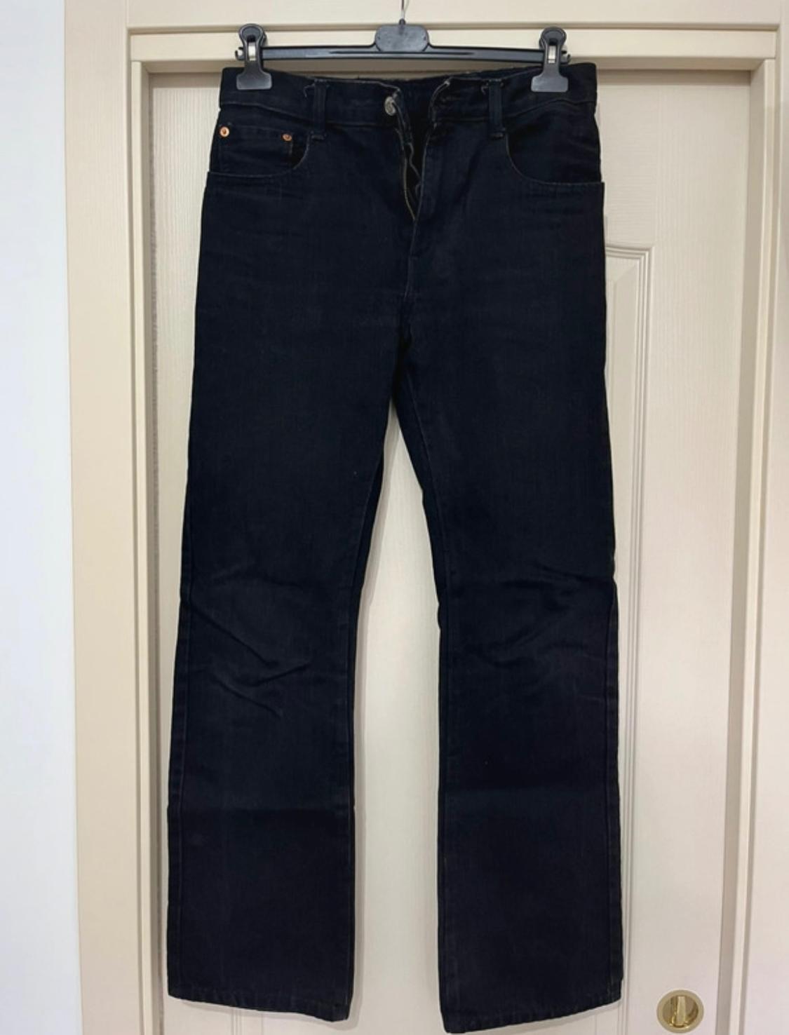 Front view of dark denim jeans with front pockets and belt loops.