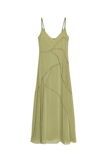 Front view of a long green dress with a V-neckline and adjustable spaghetti straps. Flowing design with decorative seams.
