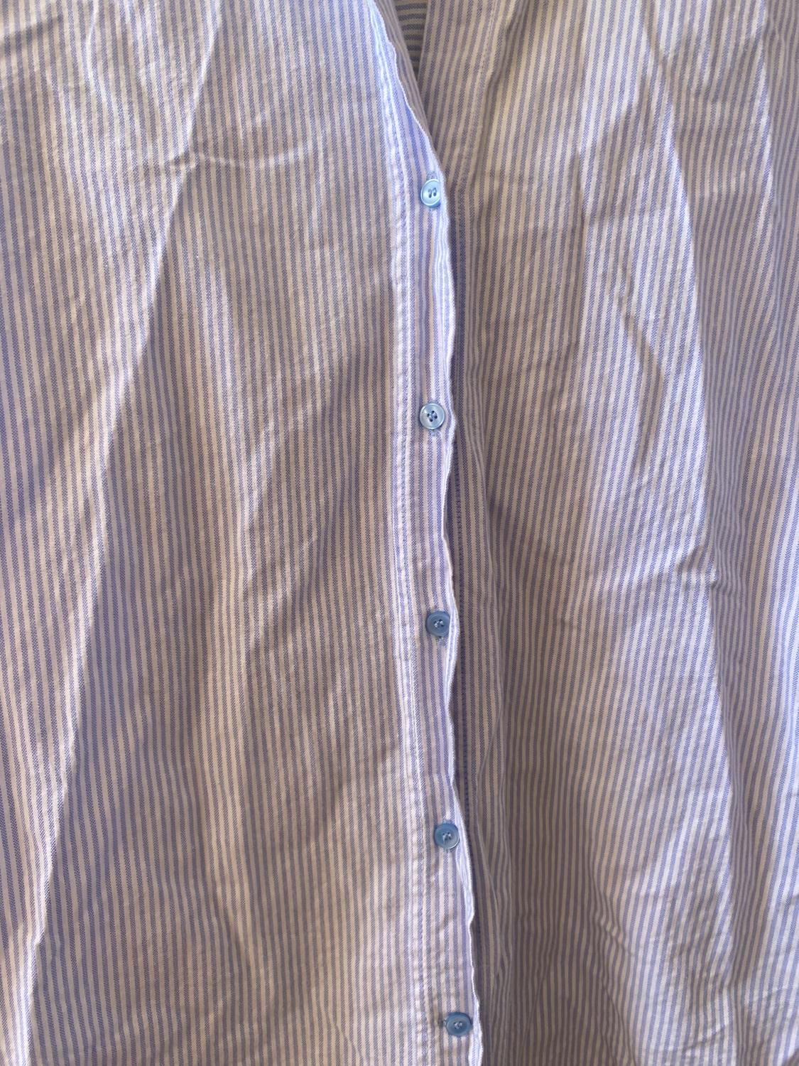Blue and white vertical striped shirt with blue buttons. Wrinkled fabric, close-up view.