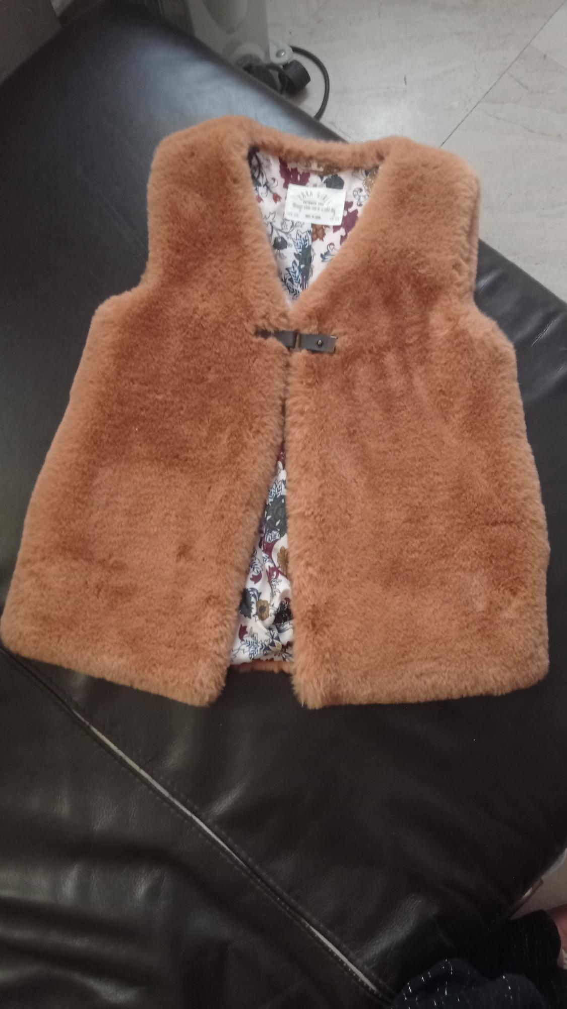 Front view of a brown waistcoat with a floral print lining and hook fastening.