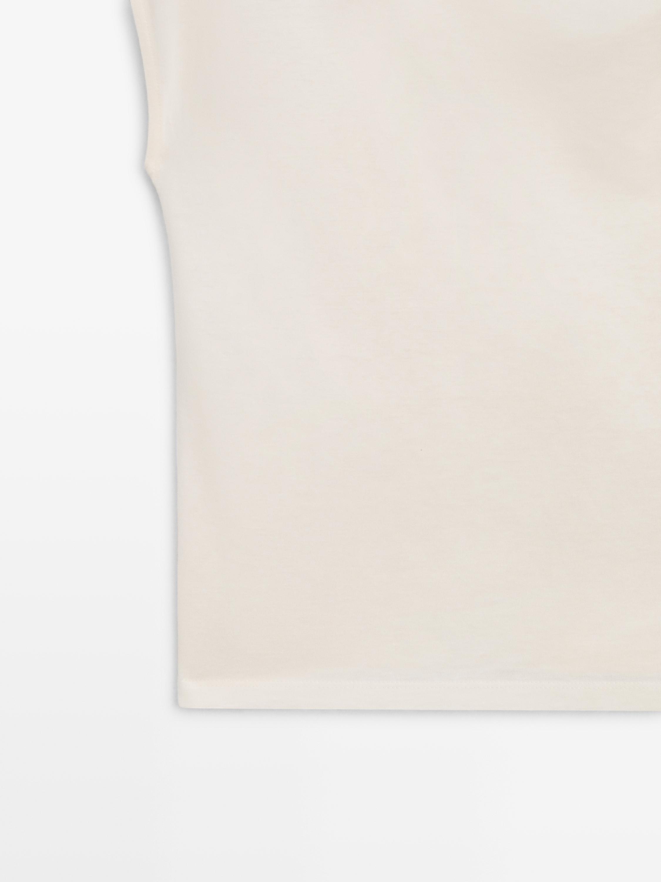 Asymmetric top with shoulder appliqué