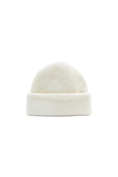 White knit beanie with a cuff, on a white background. Simple and minimalist design, ideal for a casual and modern look.