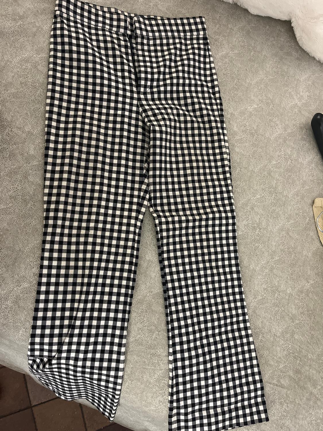 Black and white checked trousers on a textured grey surface.