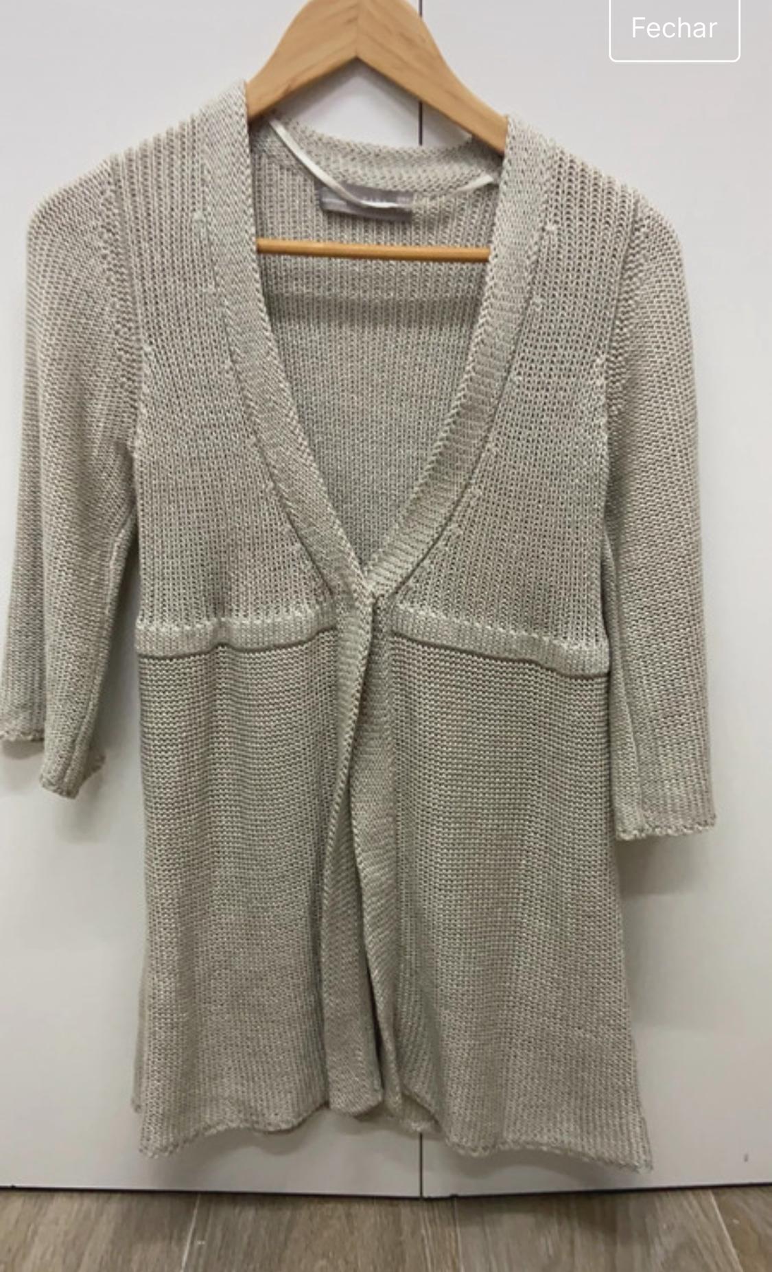 Front view of a beige knitted cardigan with three-quarter sleeves and a V-neck.