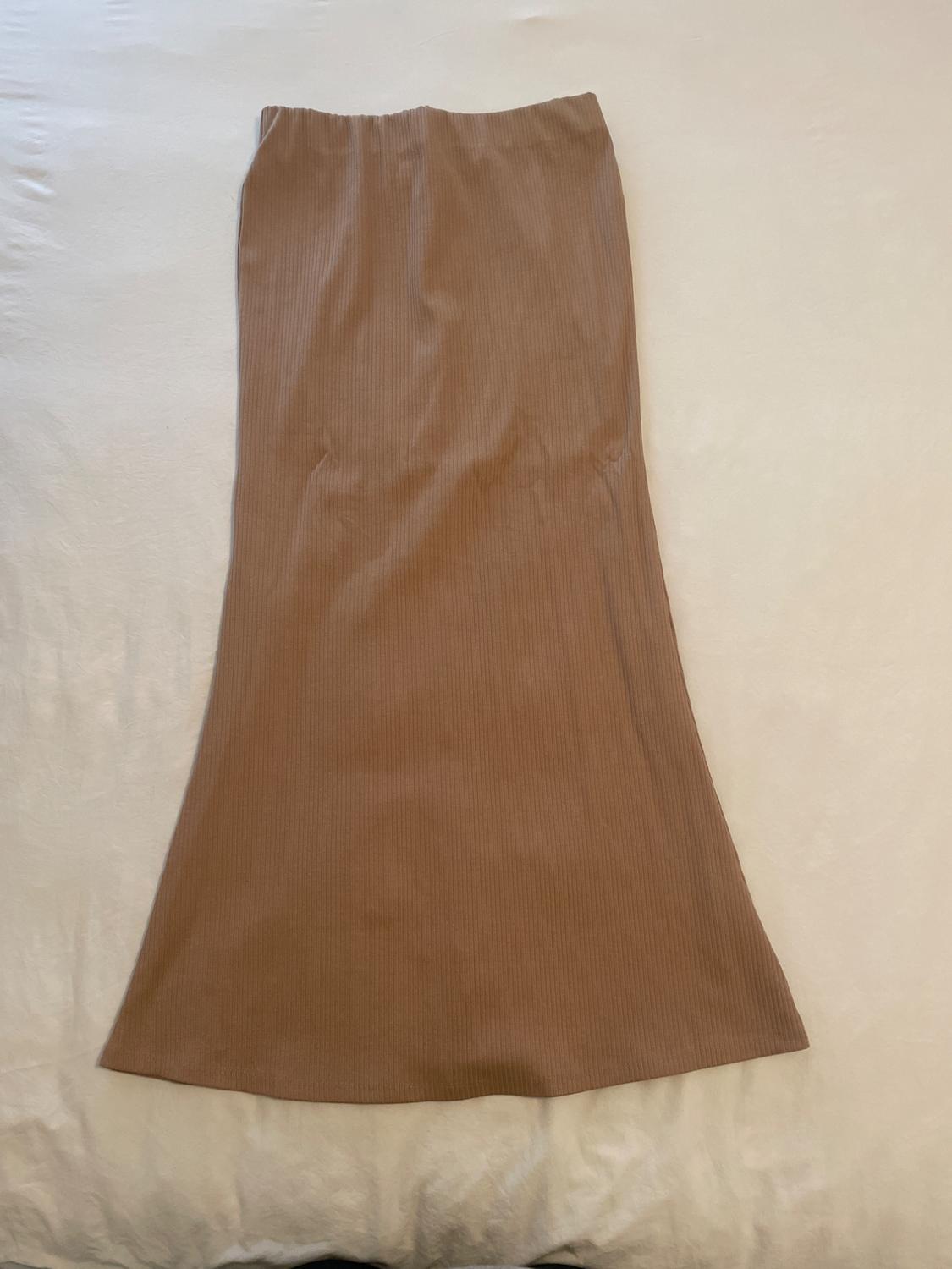 Light brown long skirt with a ribbed texture, spread out on a white surface.