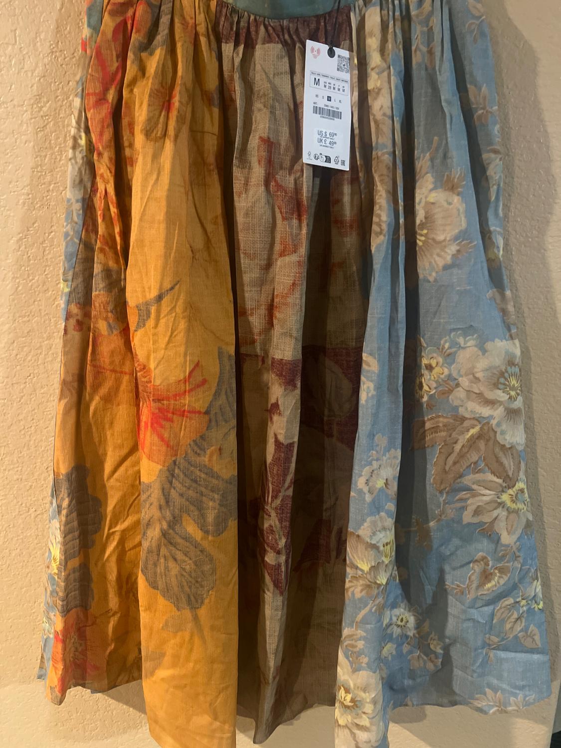 Fabric skirt with floral print in shades of brown, blue and yellow. Visible label with price in dollars and pounds.