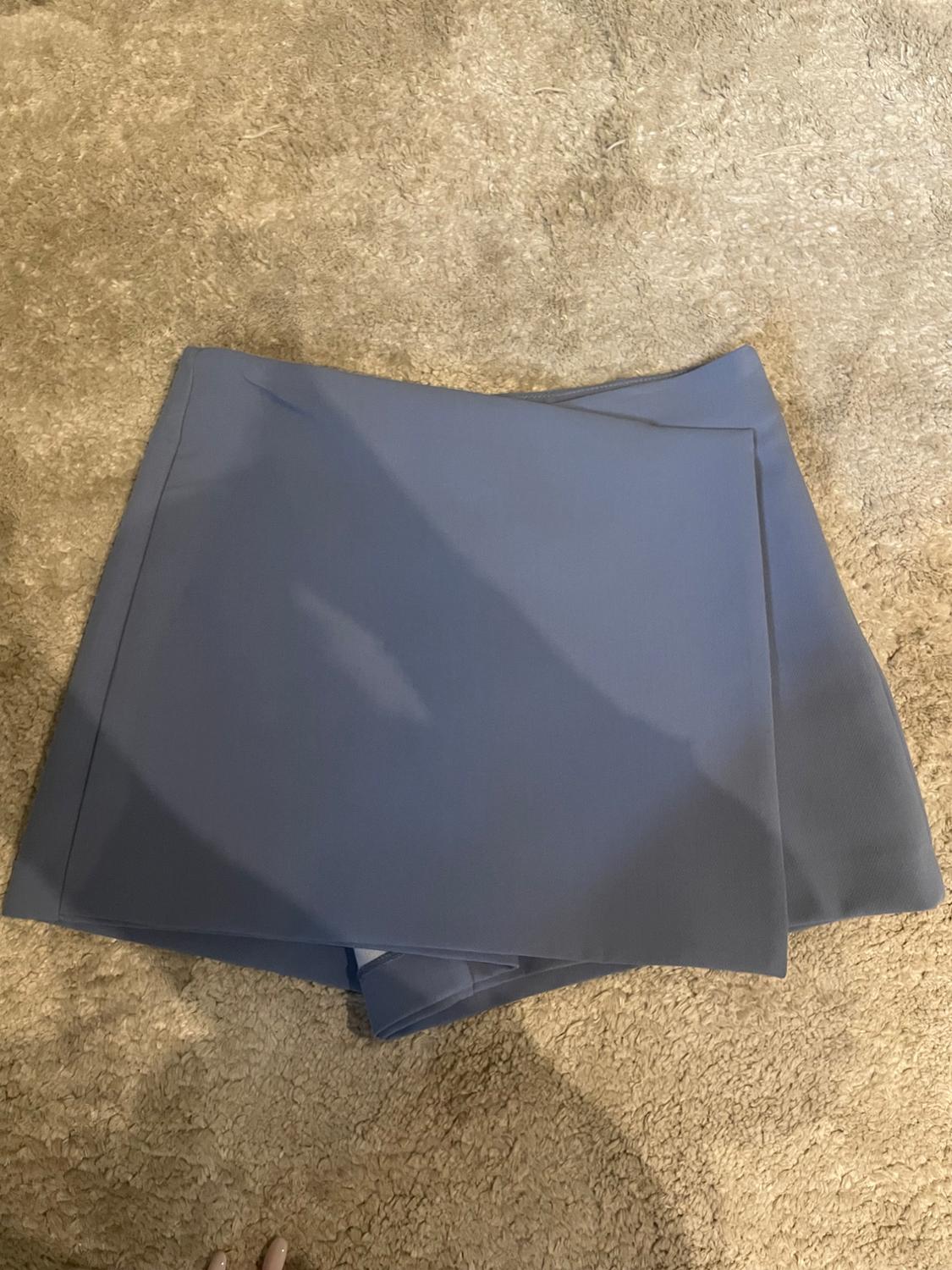 Flat blue fabric on beige carpet.