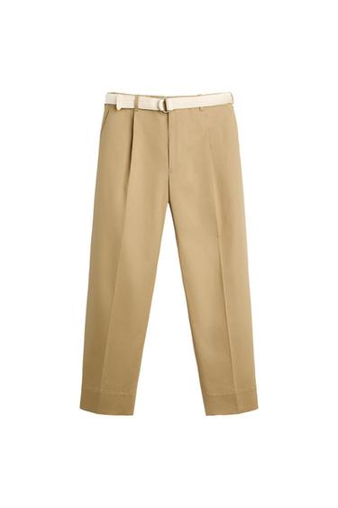 Front view of beige trousers with a white belt and side pockets.