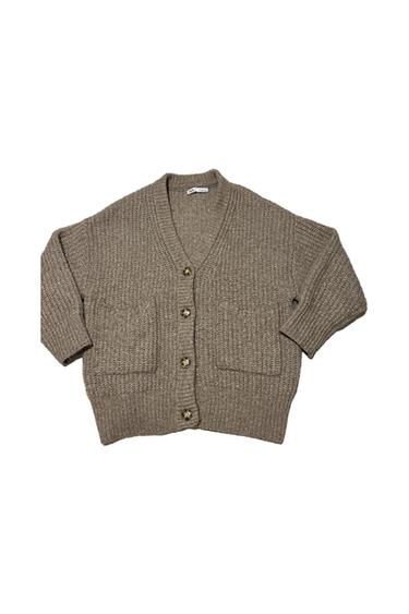 Brown knit cardigan with large buttons and two front pockets. Visible neck label. White background.