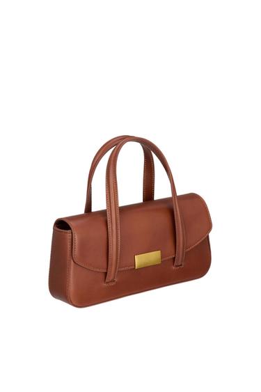 Brown handbag with double handles and a gold plaque on the front, on a white background. Elegant and minimalist design.