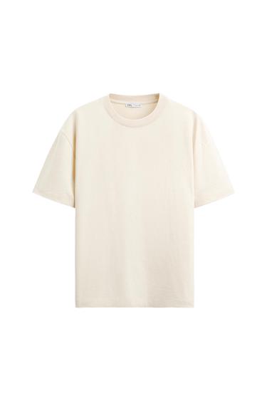 Beige short-sleeved, round-neck T-shirt on a white background. Visible label on the collar with text "Zara".