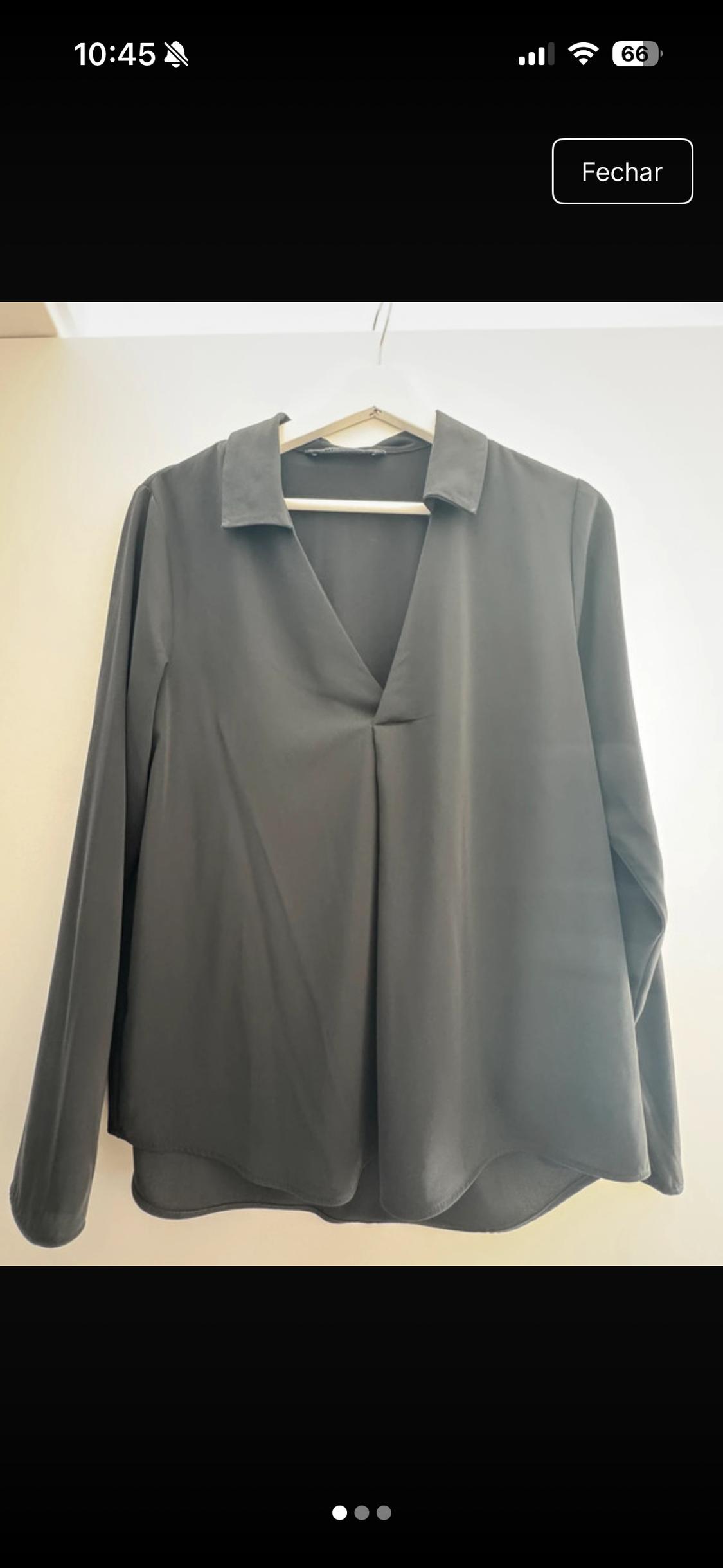 Black long-sleeved V-neck blouse hanging on a white hanger against a light background. Text: 10:45 Date 66.