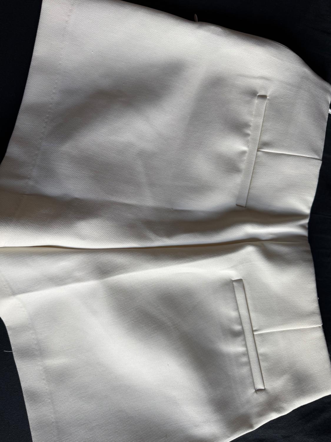 Detail of white pants with back pockets.