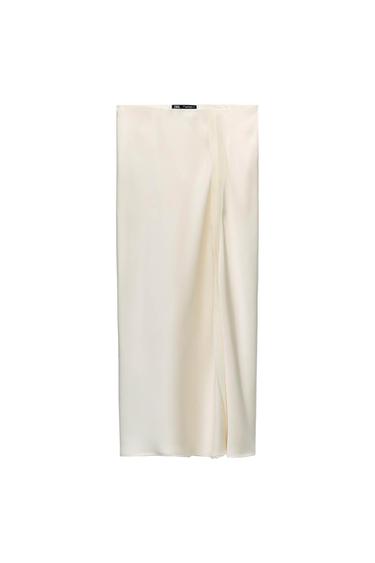 White long skirt with a front slit, hanging against a white background. Black label visible at the top.