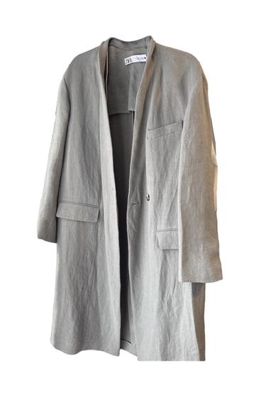 Light grey long coat with flap pockets and Zara label on the inside, on a white background.