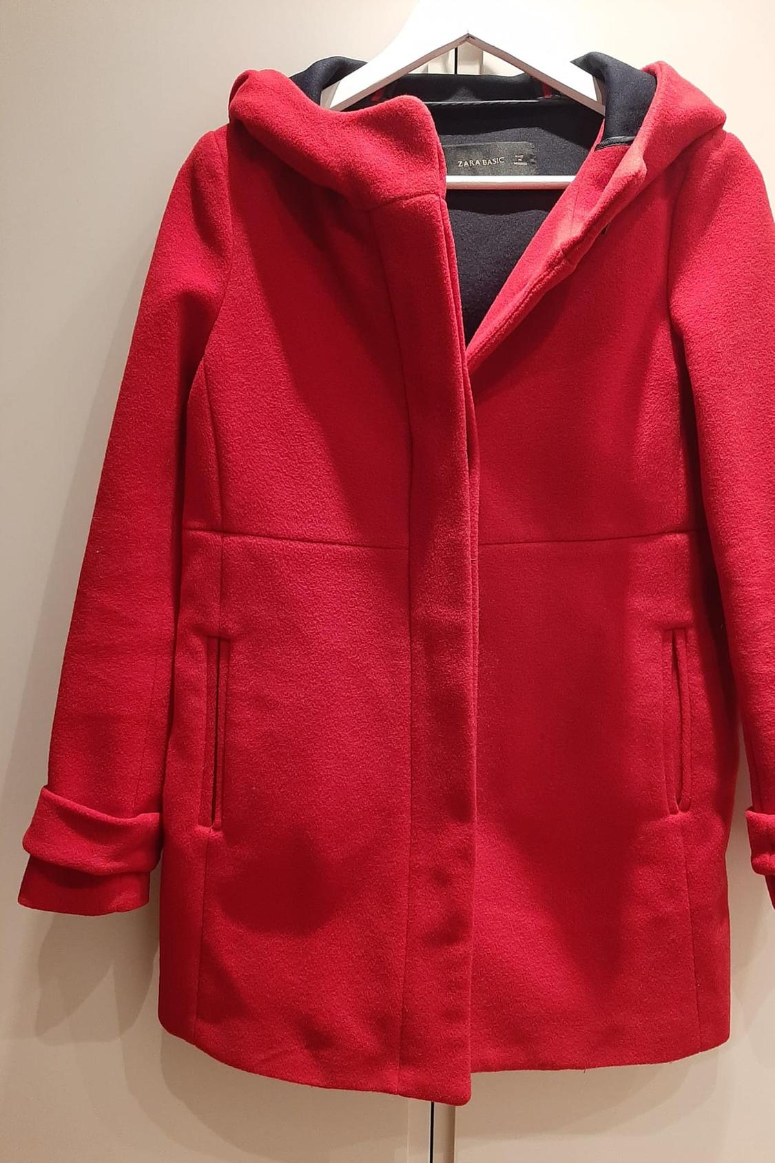 Front view of a red hooded coat with side pockets.
