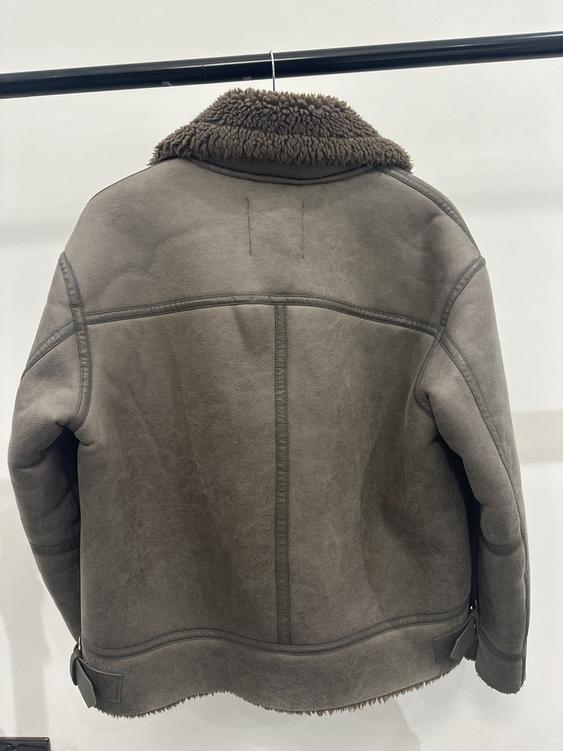 Brown jacket with a wool collar, rear view, hanging on a black hanger against a white background.
