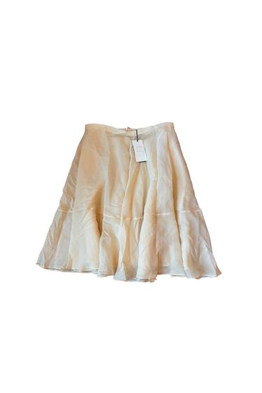 Cream-coloured flared skirt in a lightweight fabric with a horizontal seam and label at the waist, on a white background.