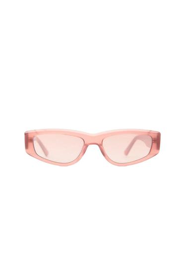 Retro-style sunglasses with a translucent light pink frame and lenses against a white background.