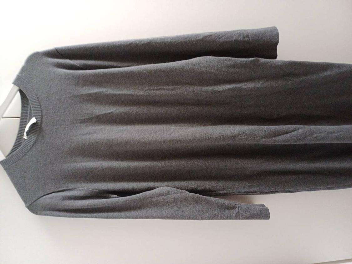 Grey long-sleeved dress hanging on a white hanger against a light background.