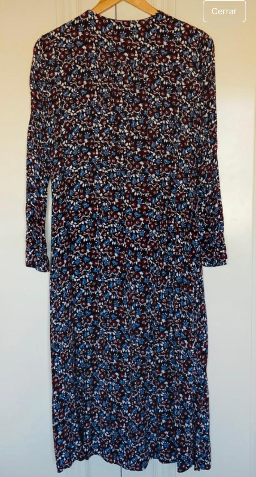 Long dress with a floral print in blue and burgundy tones, hanging on a wooden hanger. Visible text: "Close".