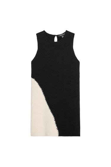 Sleeveless black and white dress with an asymmetrical design. Black top with an open back detail.