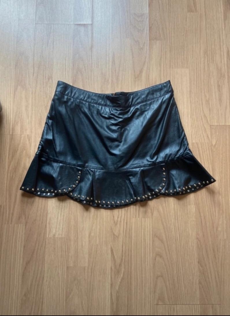 Front view of a black skirt with ruffles and studs on the hem.