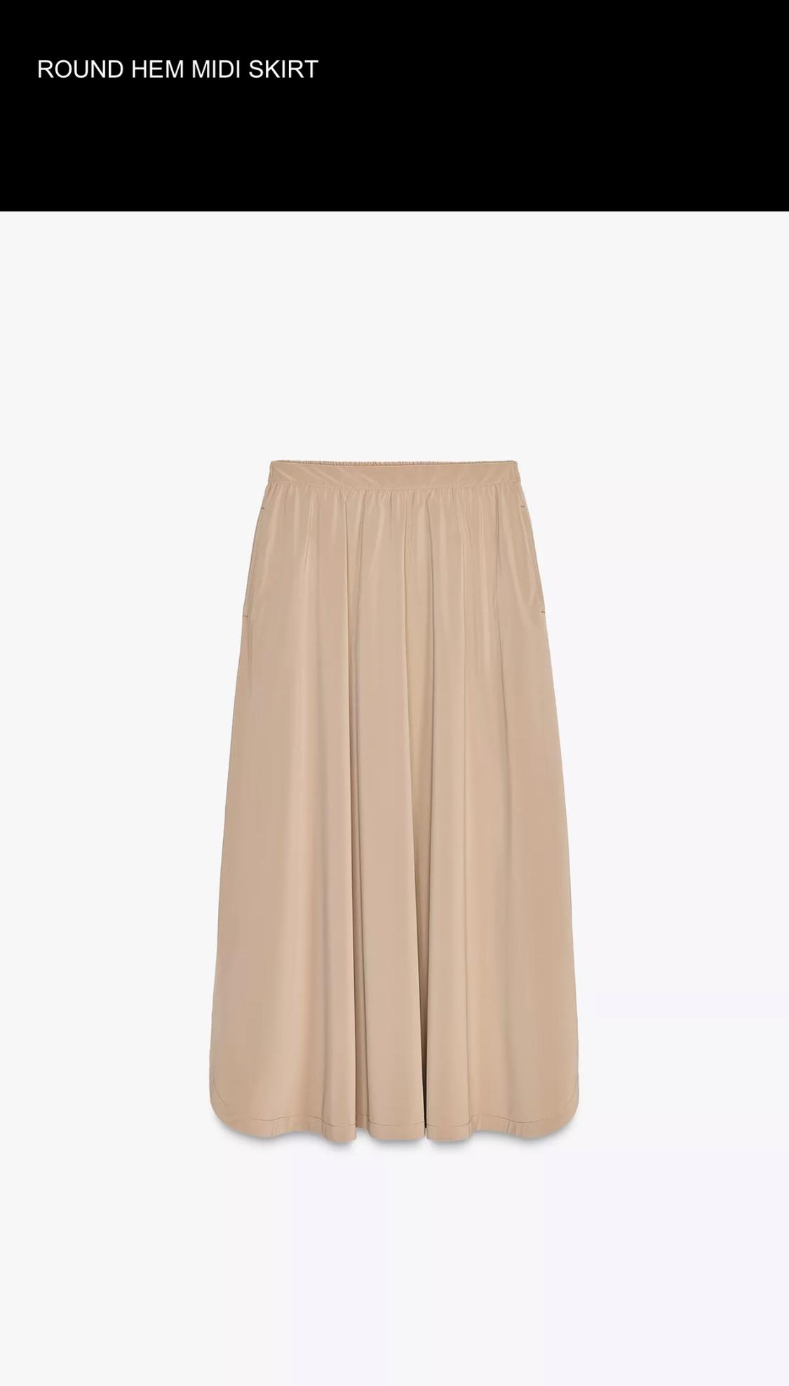 Beige midi skirt with rounded hem on a white background. Text at the top: "ROUND HEM MIDI SKIRT".