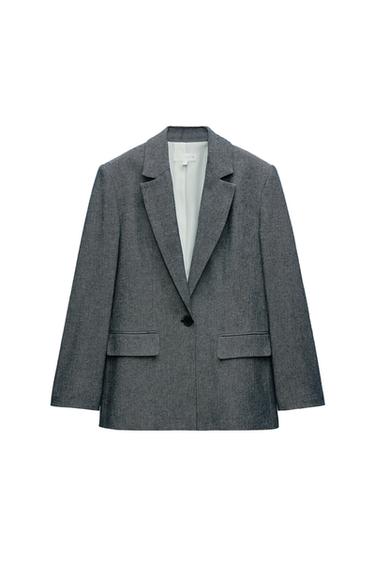 Front view of gray jacket with lapel and one button, front pockets with flap.