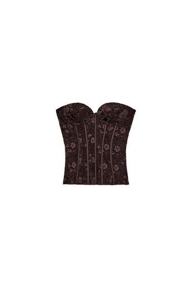 Front view of a brown corset with floral lace, a sweetheart neckline, and visible boning.