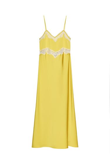 Front view of a mustard midi dress with a V-neck, thin adjustable straps and contrasting lace and trim detailing.