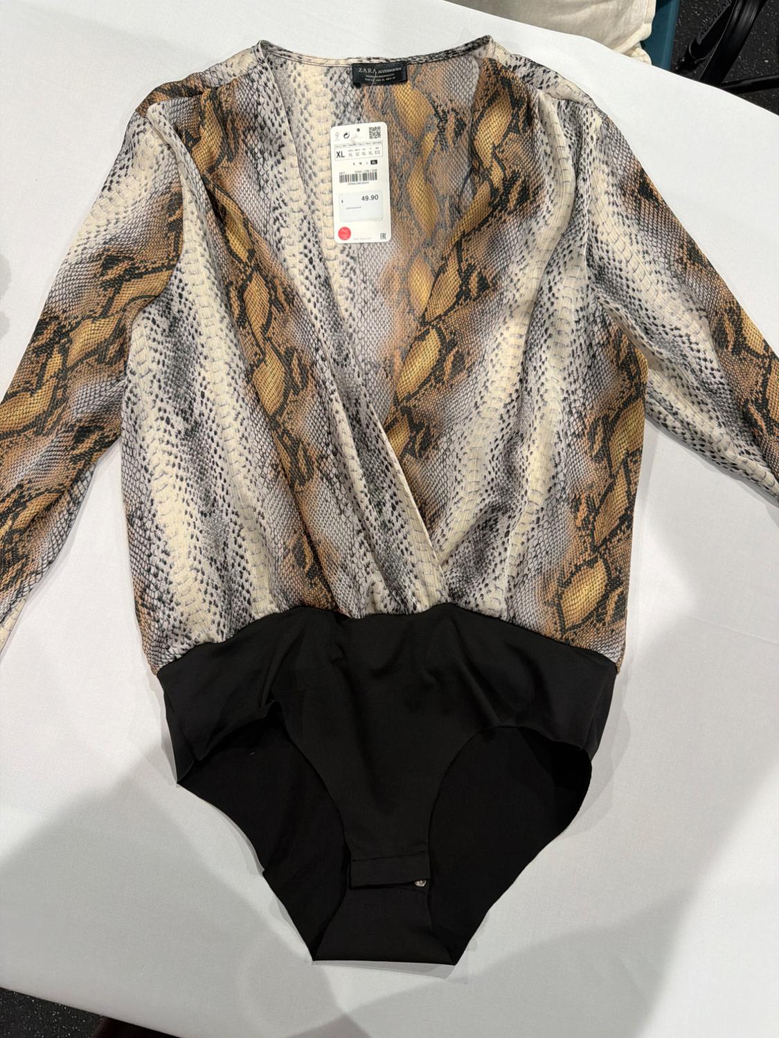 Long-sleeved wrap-over bodysuit in snake print with black bottom on white background. Label with text ZARA XL 49.90.