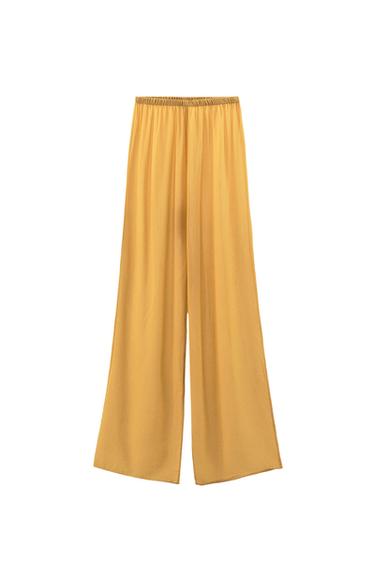 Flowy wide-leg trousers in mustard yellow with an elasticated waist on a white background.