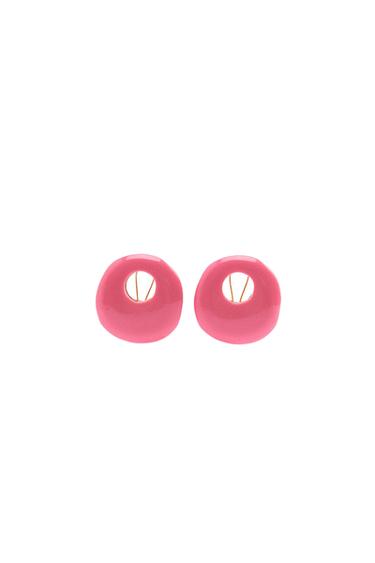 Pink round earrings with a hollow design in the centre, on a white background.
