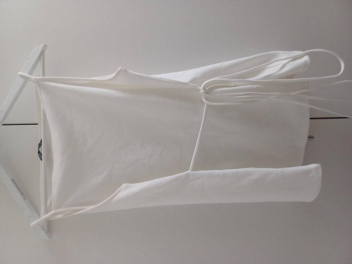 White dress hanging on a white hanger against a light background. The dress has thin straps and a simple design.
