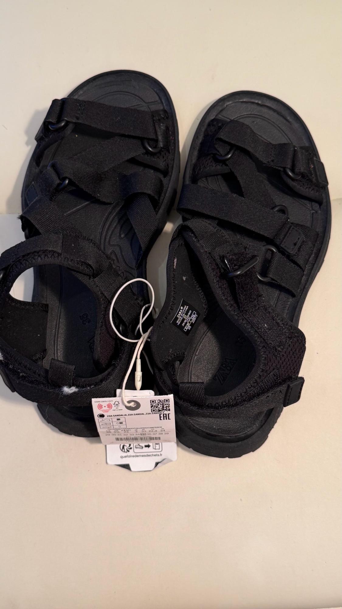 Black strappy sandals. Visible text: ZARA, 35, MADE IN CHINA, Z3A SANDALIA, EAC, quefairedemesdechets.fr