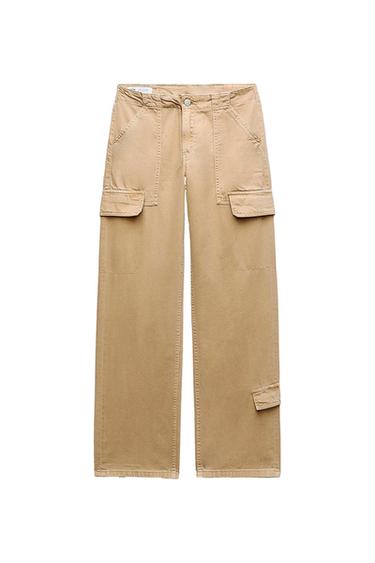 Beige cargo trousers with large side pockets and button fastening, presented on a white background.