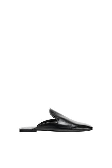 Black leather slingback shoe viewed in profile against a white background,
with a minimalist design and plenty of space at the top.