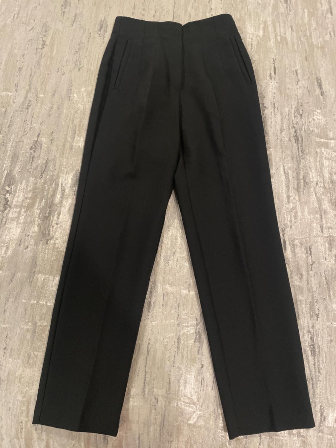 Front view of black trousers with side pockets.