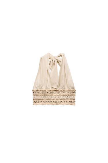 Back view of beige top with lace and bow at the back.