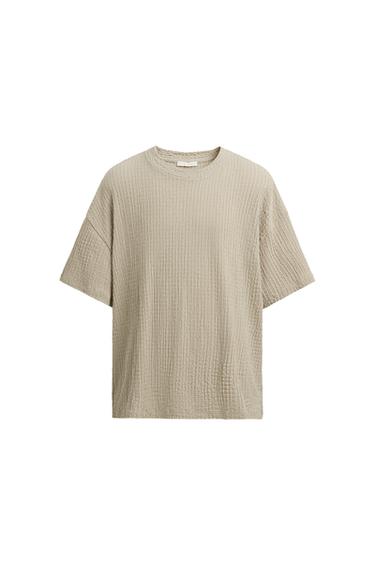 Front view of a beige t-shirt with ribbed texture and short sleeves.