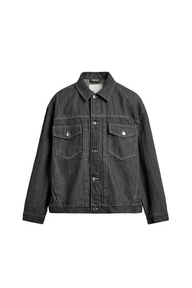 Front view of an oversized grey jacket with a lapel collar, central button fastening, patch pockets with flaps, and jetted pockets.