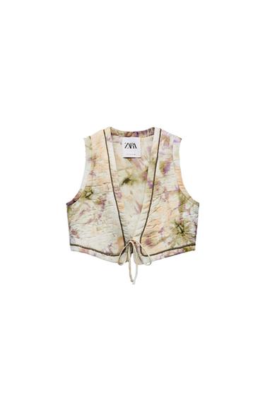 Front view of a printed waistcoat with a bow at the front and a visible 'ZARA' label.