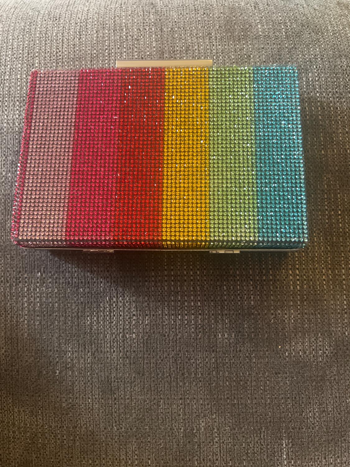 Top view of a clutch bag with a stripe design in red, yellow, green, and blue colors with rhinestones.